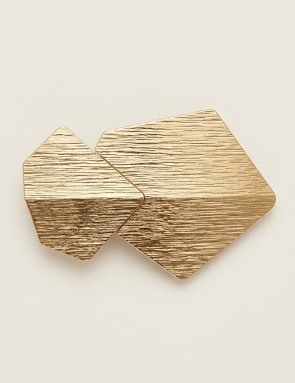 Passant géométrique doré brossé de face, finition micro-striée à deux polygones superposés pour vêtements et maroquinerie.