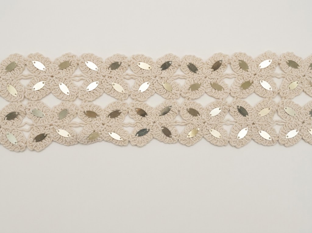 GAL-COT-0000001-80MM Galon ajouré au crochet en pur coton coloris écru tombé de métier de 80 mm de largeur, orné de motifs floraux géométriques brodés de paillettes navettes métallisées pour la confection vestimentaire, la customisation et la décoration textile.